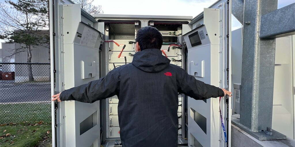 man opening TROES' battery energy storage system