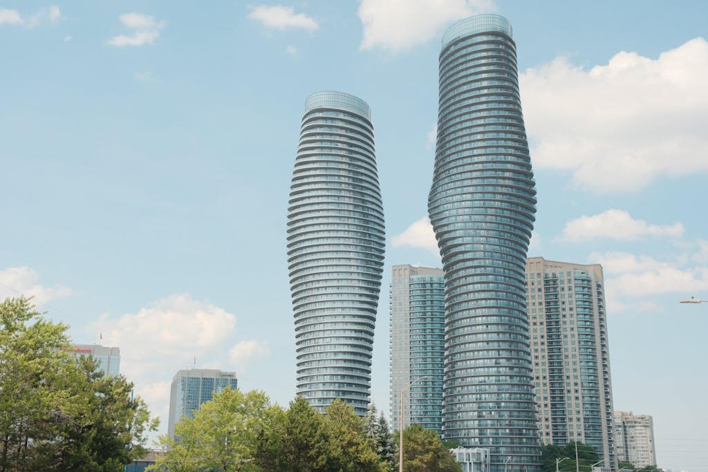 The iconic Absolute Towers of Mississauga, also known as the Marilyn Monroe Towers, against a bright blue sky.